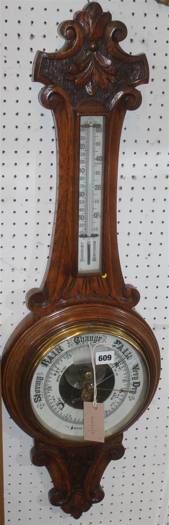 Oak aneroid wheel barometer in leaf-carved case, with thermometer (dial cracked)